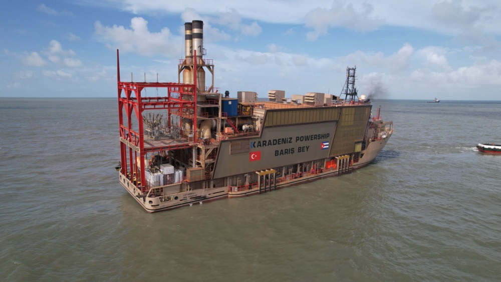 A large floating power plant on a large body of water. The side reads "Karadeniz Powership Baris Bey."