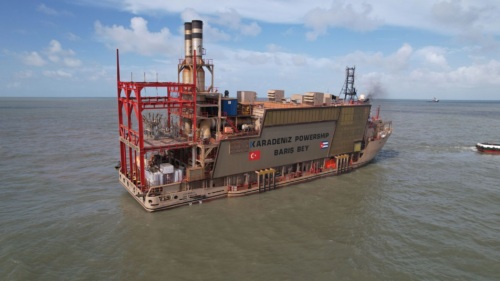 A large floating power plant on a large body of water. The side reads "Karadeniz Powership Baris Bey."