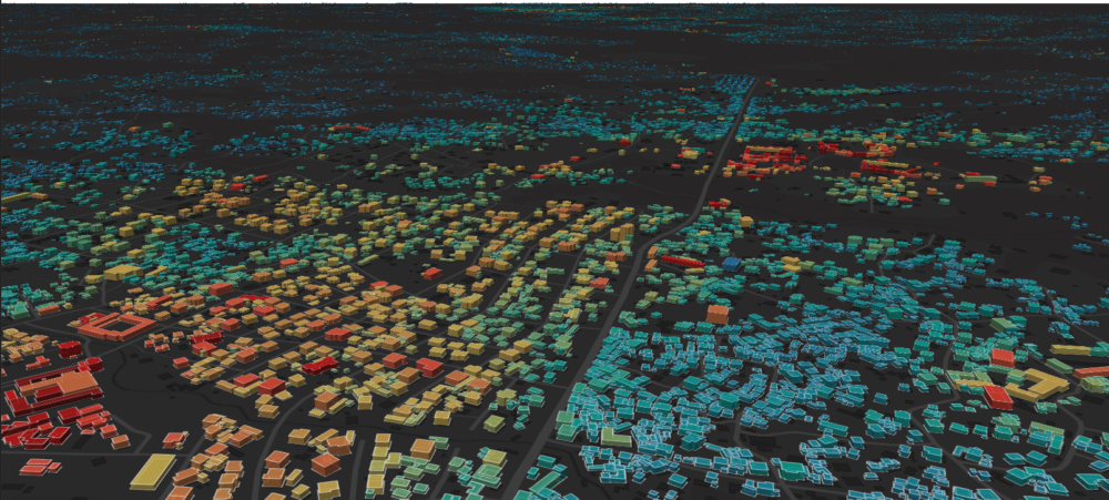A rendering of buildings with a heatmap overlaid on top of them that shows electricity use in different buildings. The cast of the image is black and the buildings appear in a range of colors from blue to red.